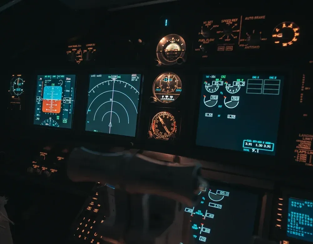 A cockpit of an airplane with a lot of monitors and buttons