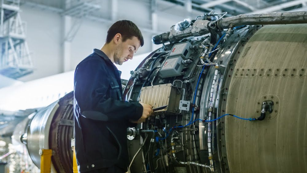 plane technician looking for corrosion in aircraft jets