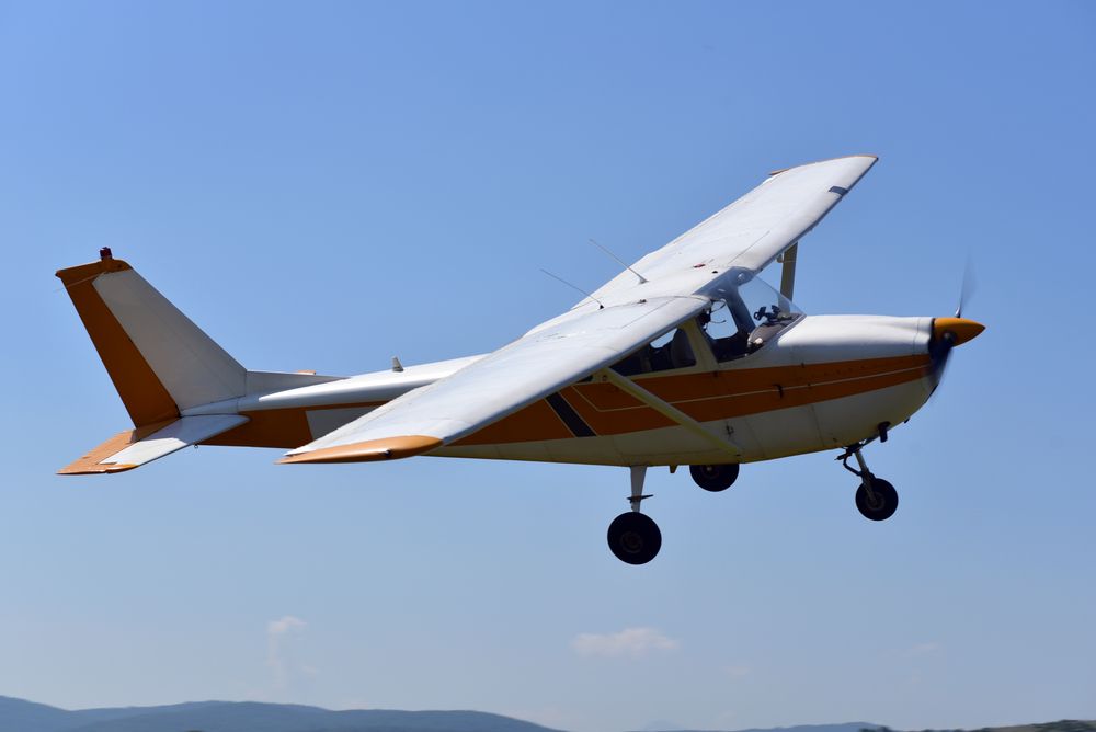 A small plane is flying through a clear blue sky.