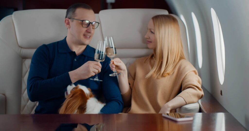 A man and a woman are toasting with champagne on a private jet.