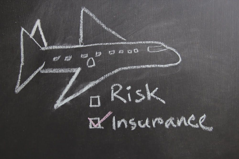 A chalkboard with a drawing of an airplane and the words risk insurance