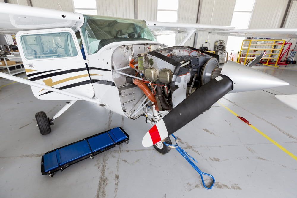 A small plane is being repaired in a hangar.