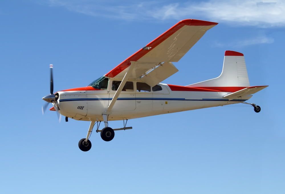 A small plane is flying through a blue sky