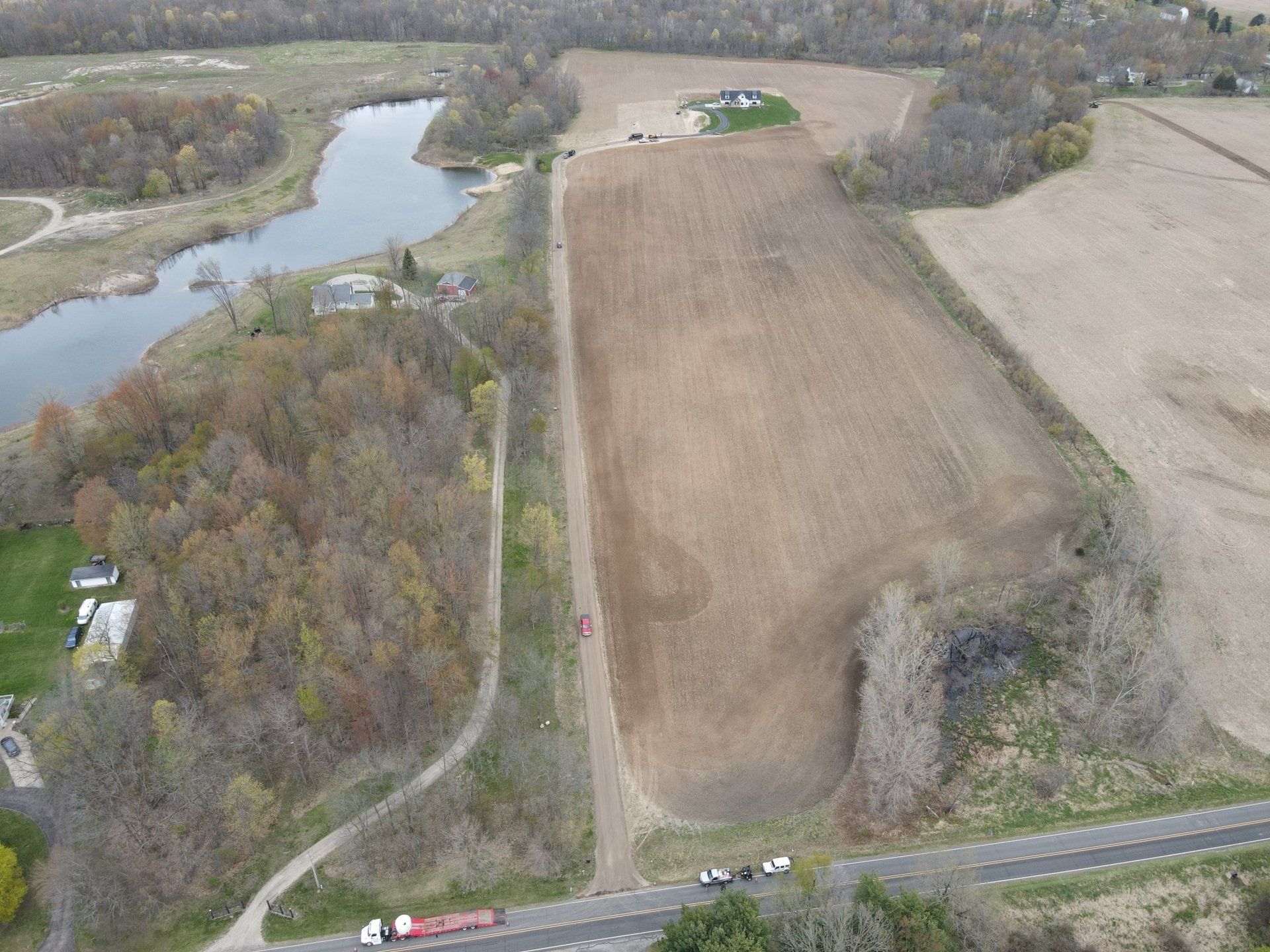 An aerial view of a large field with a river in the background.