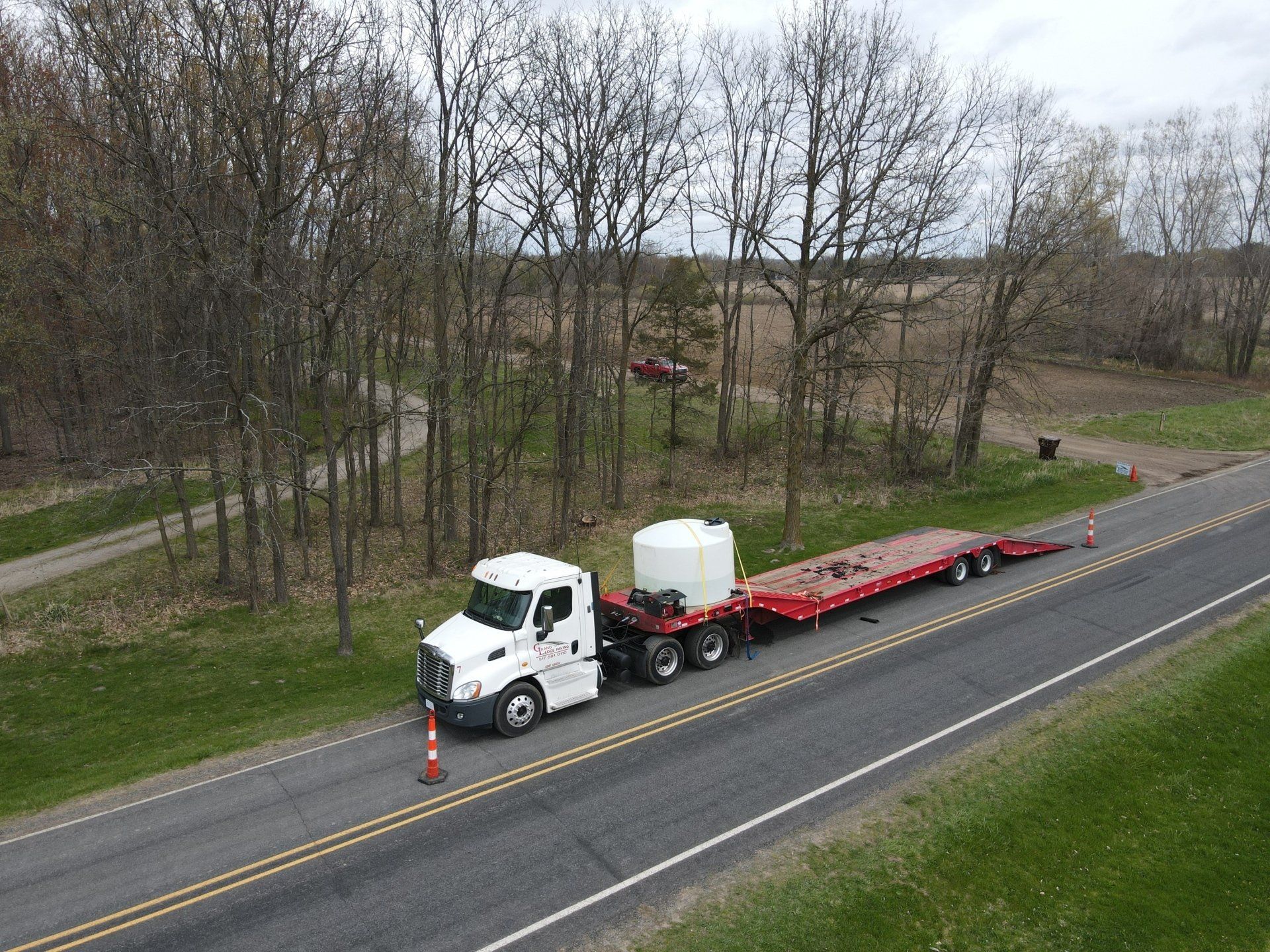 An aerial view of a semi truck driving down a highway.
