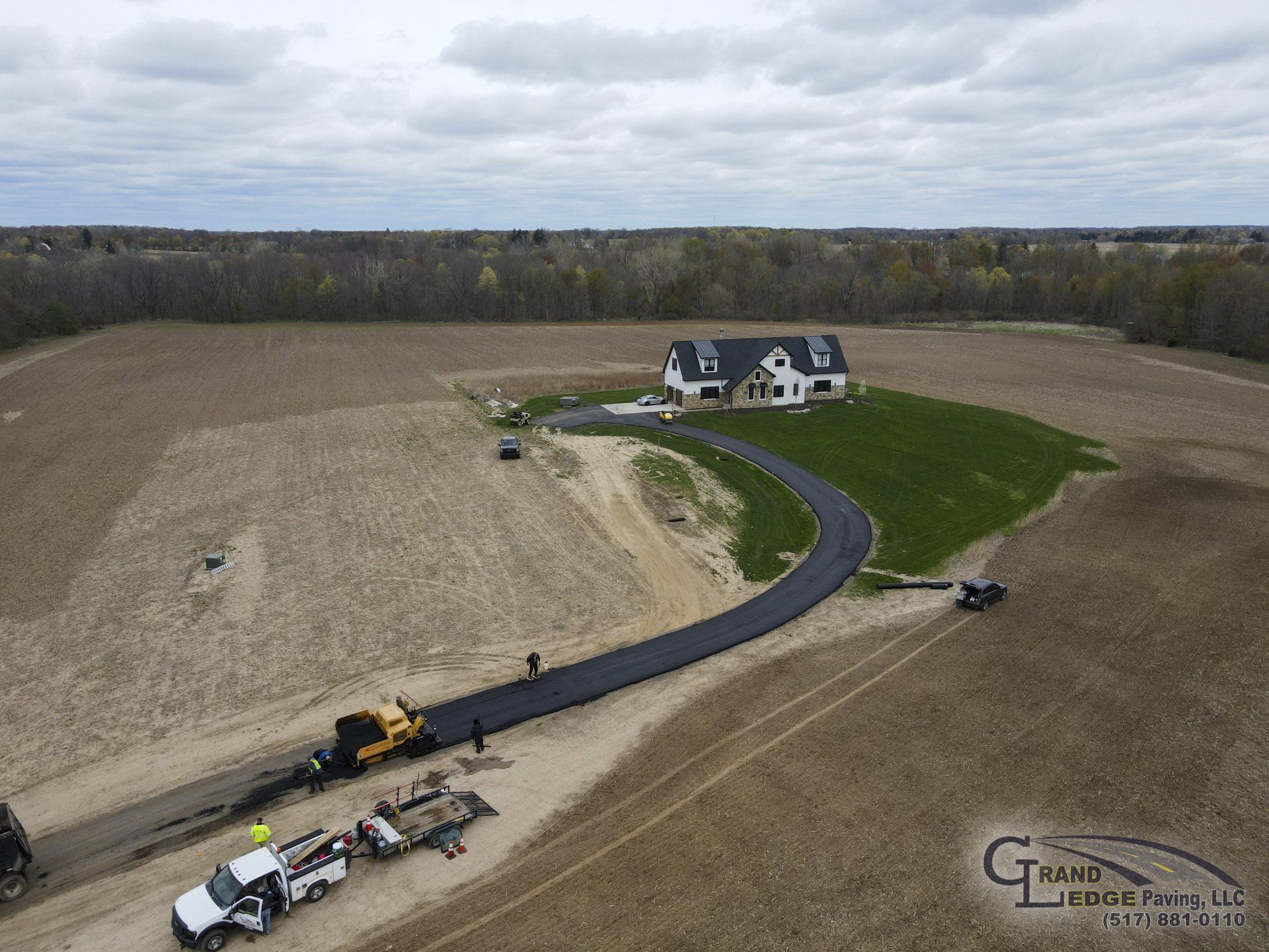 An aerial view of a road being built in front of a house.