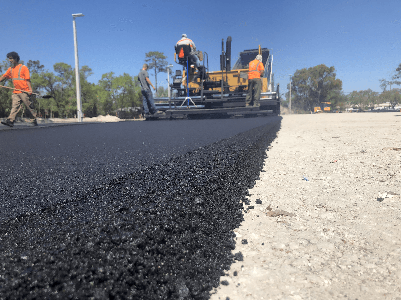 A group of construction workers are working on a road.