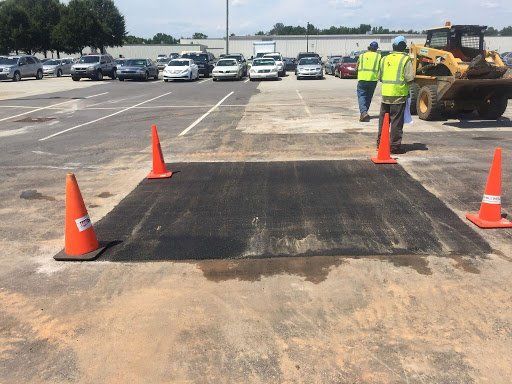 A group of construction workers are walking through a parking lot.