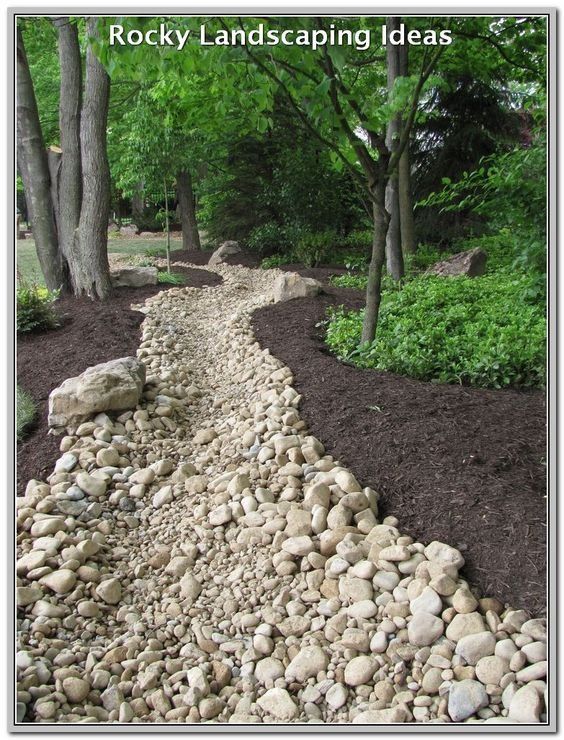 A picture of rocky landscaping ideas with trees in the background