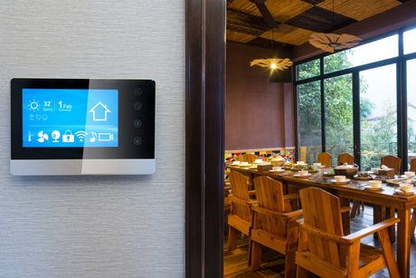 smarthome monitor on the wall outside a dining room