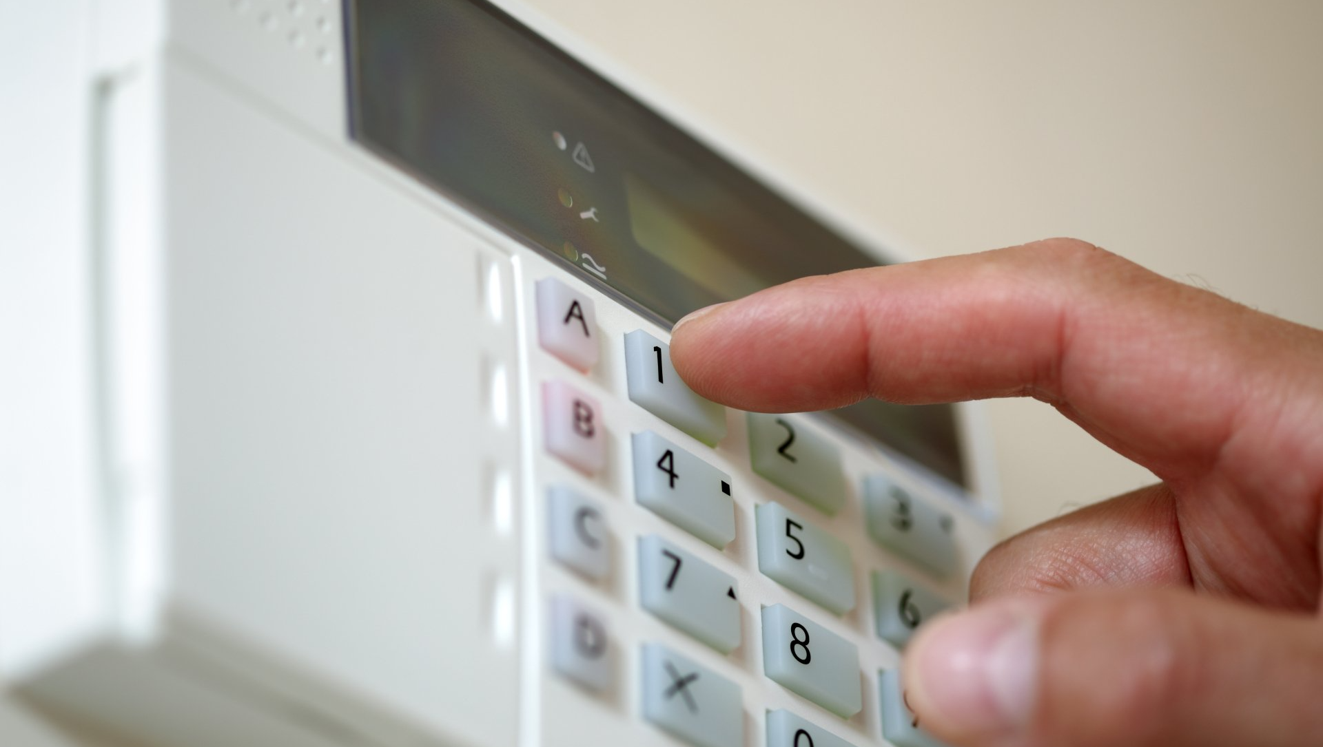 Close up of hand pushing numbers on an alarm keypad