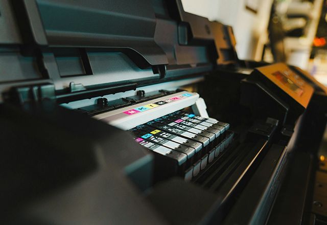 A close up of a printer with colorful ink cartridges.