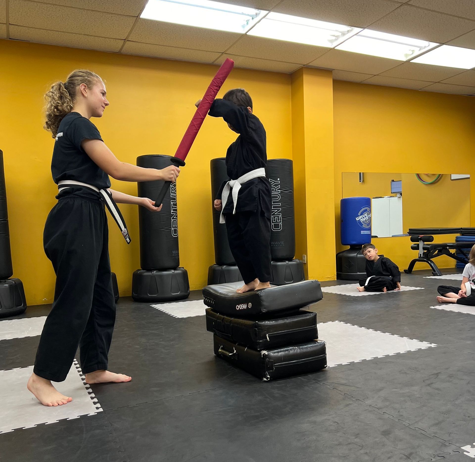 Young boy standing on a pile of pads practicing blocking. 