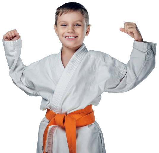 Boy in karate uniform, smiling, fist clenched, hand raised to forehead, white background.