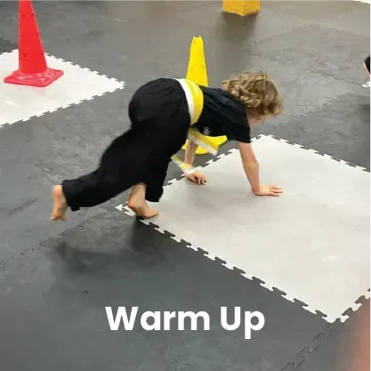 Child in karate uniform doing warm-up exercise on a padded floor with cones.