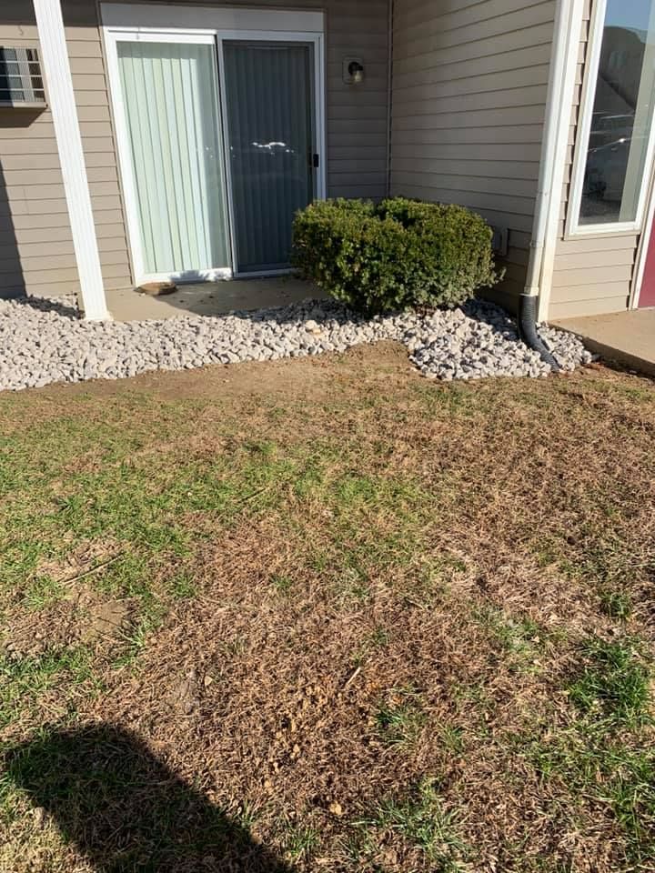 A house with a sliding glass door and a lawn in front of it.