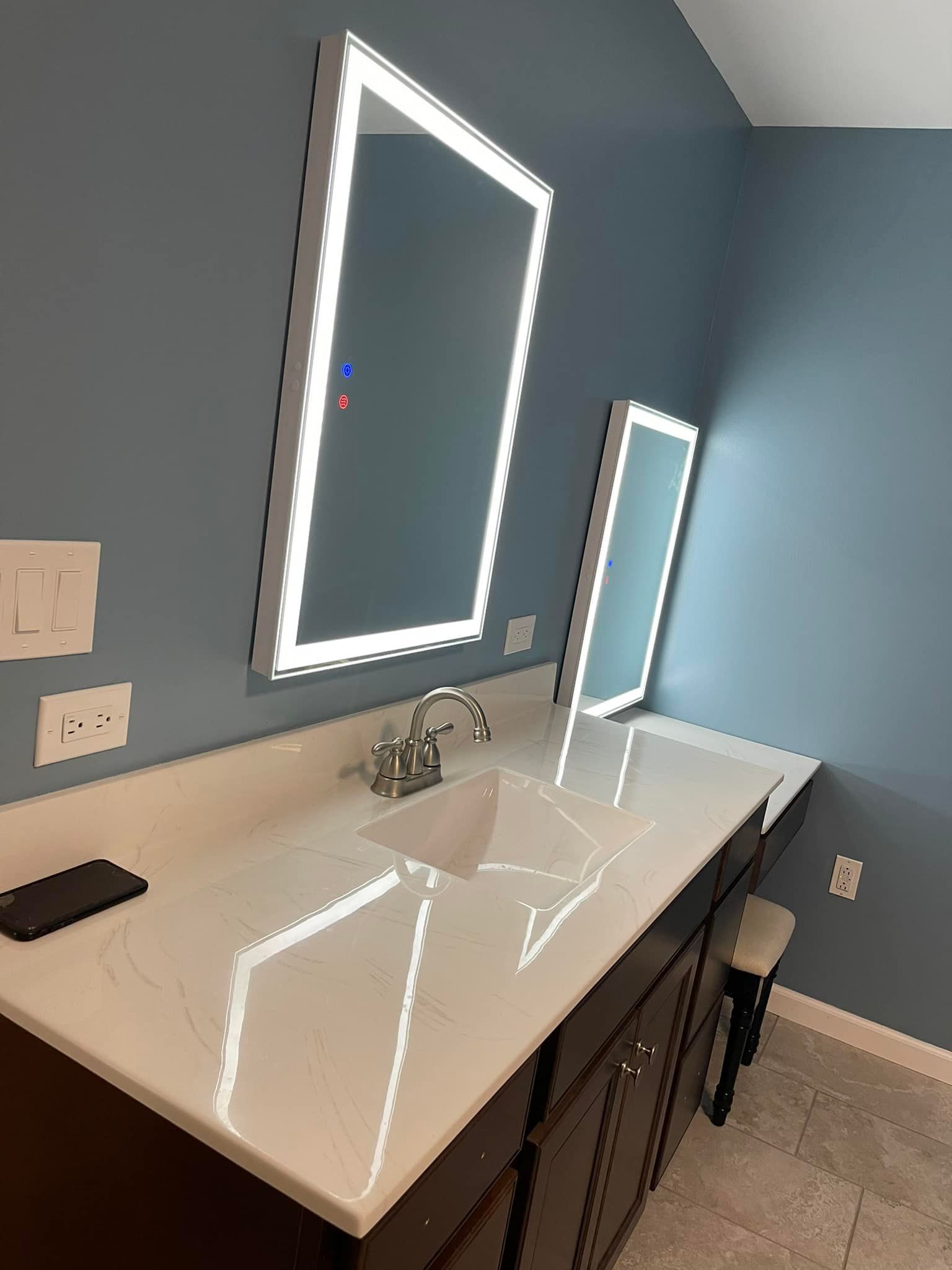 A bathroom with two mirrors and a sink.