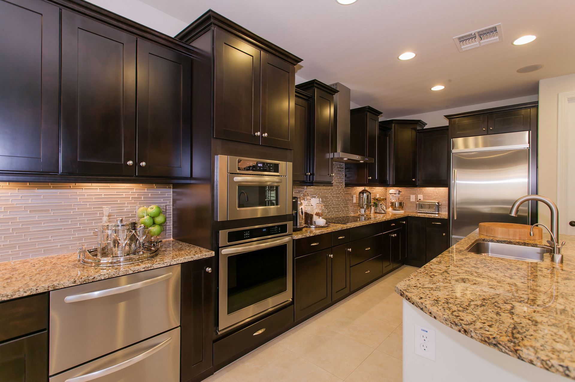 Kitchen with dark wood cabinets, stainless steel appliances, and granite countertops.