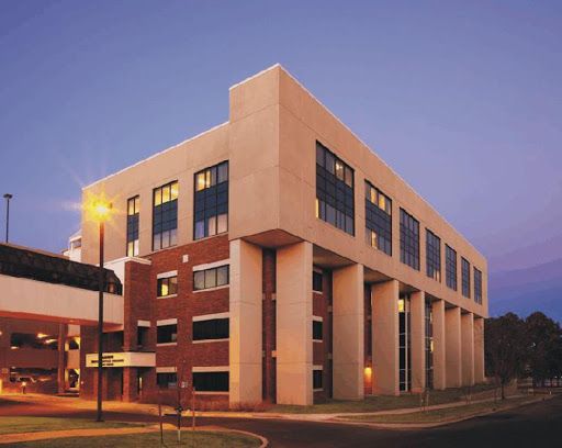 A large building with a lot of windows is lit up at night