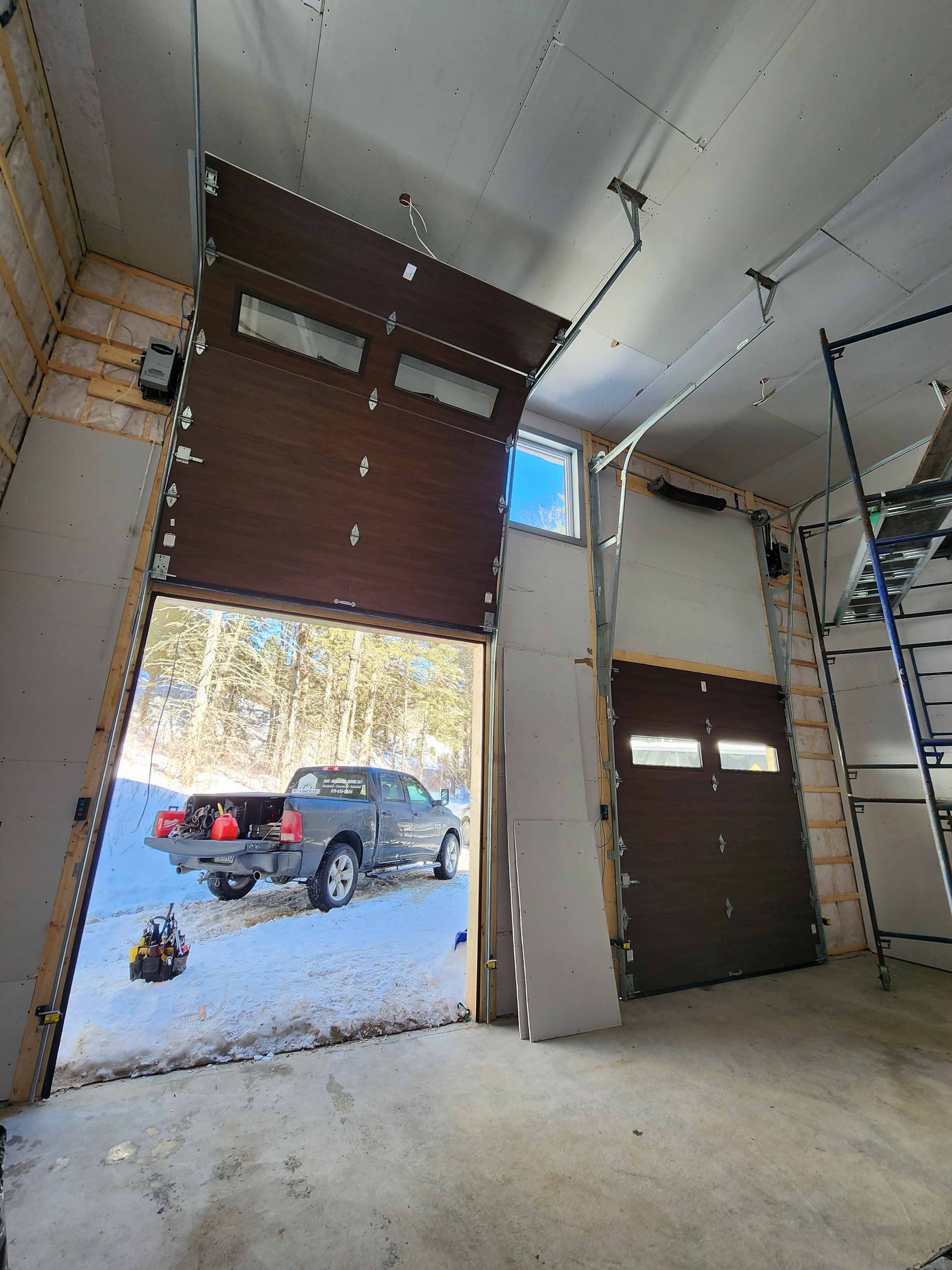 Un camion est garé dans un garage avec la porte ouverte.