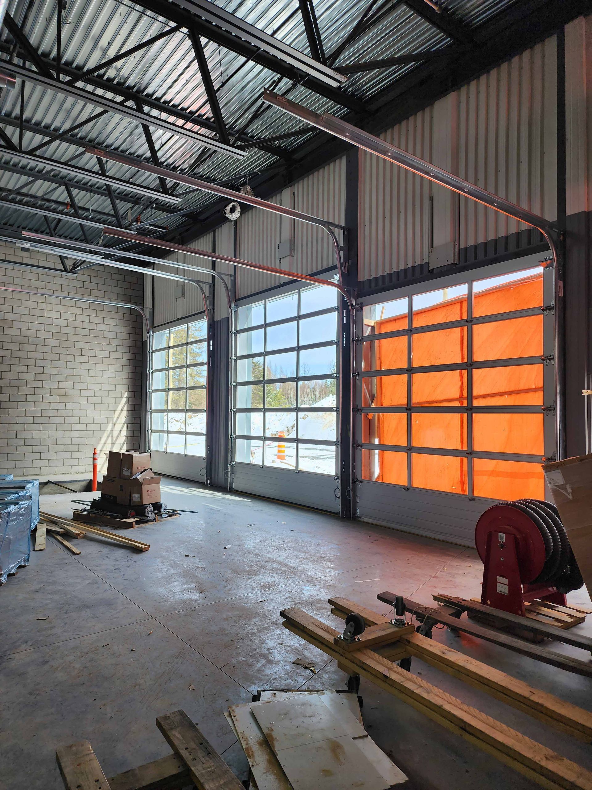 Un grand entrepôt avec beaucoup de fenêtres et un enrouleur de tuyau.