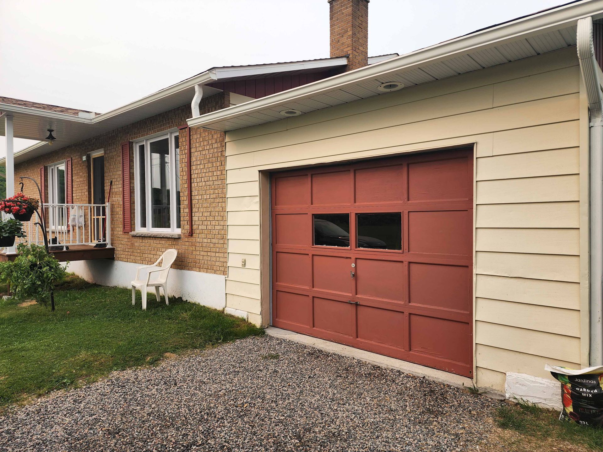 Une porte de garage rouge se trouve devant une maison.