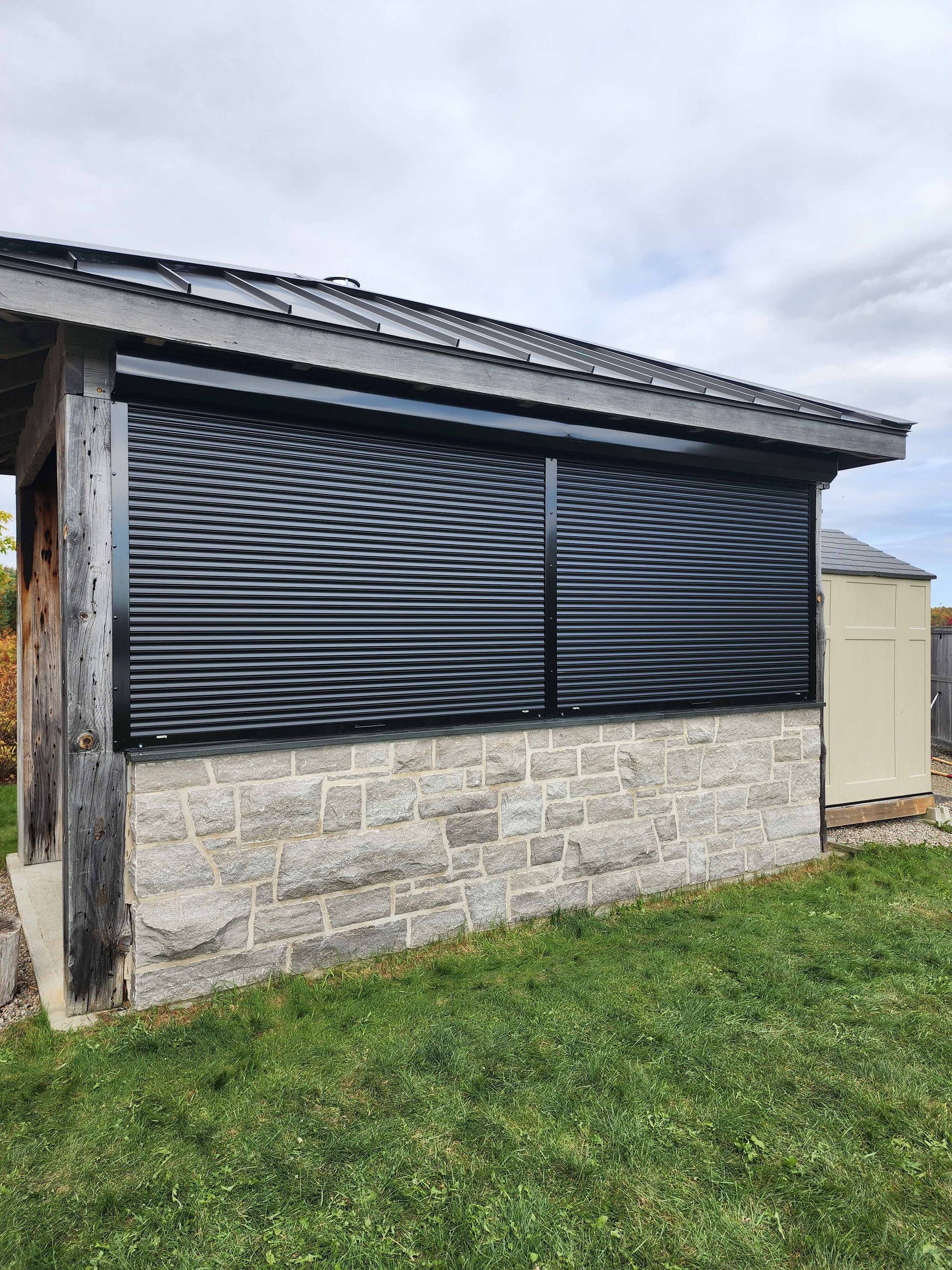 Un bâtiment en briques avec un volet noir sur le côté.