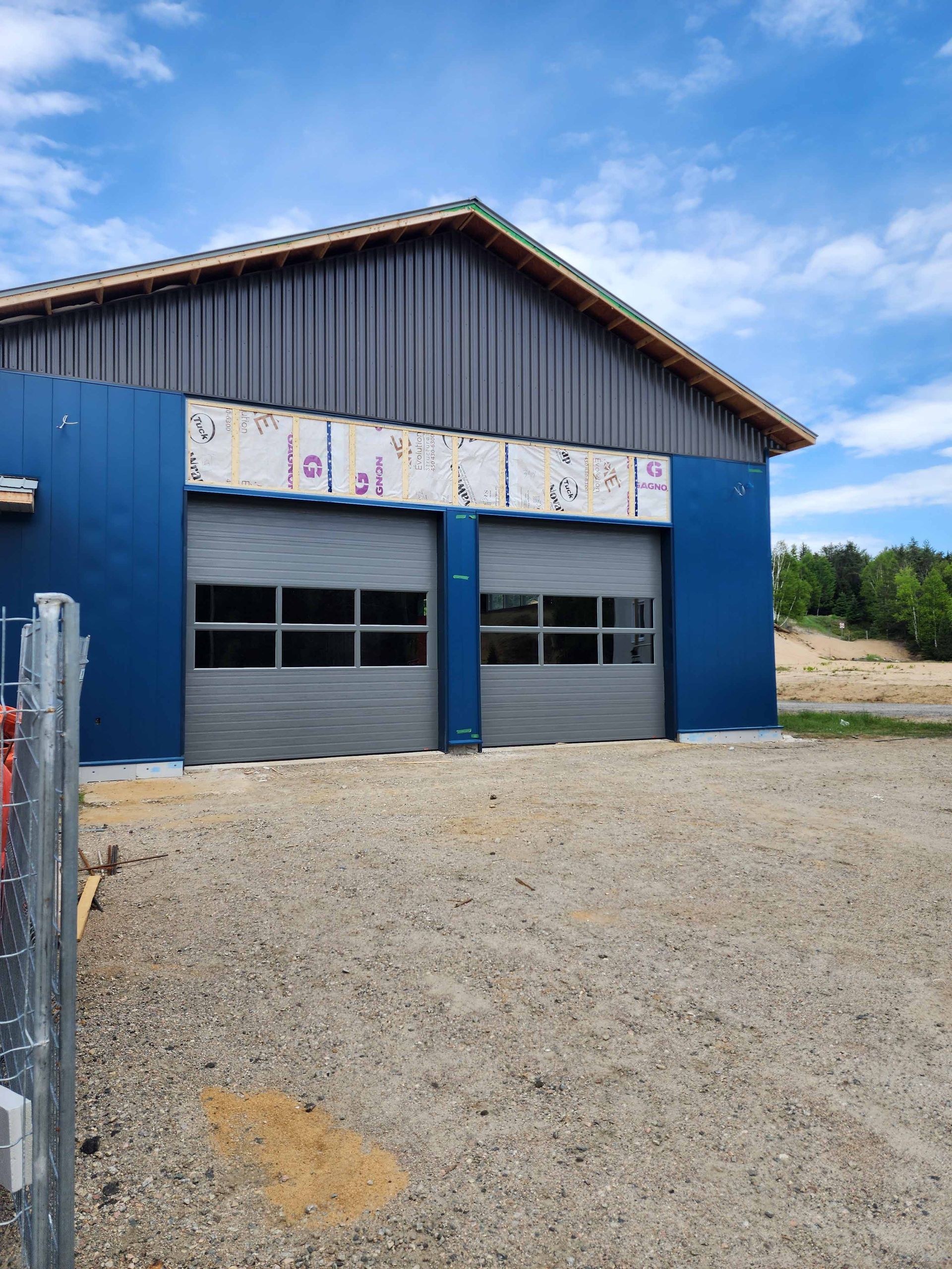 Un bâtiment bleu avec un toit et une porte de garage