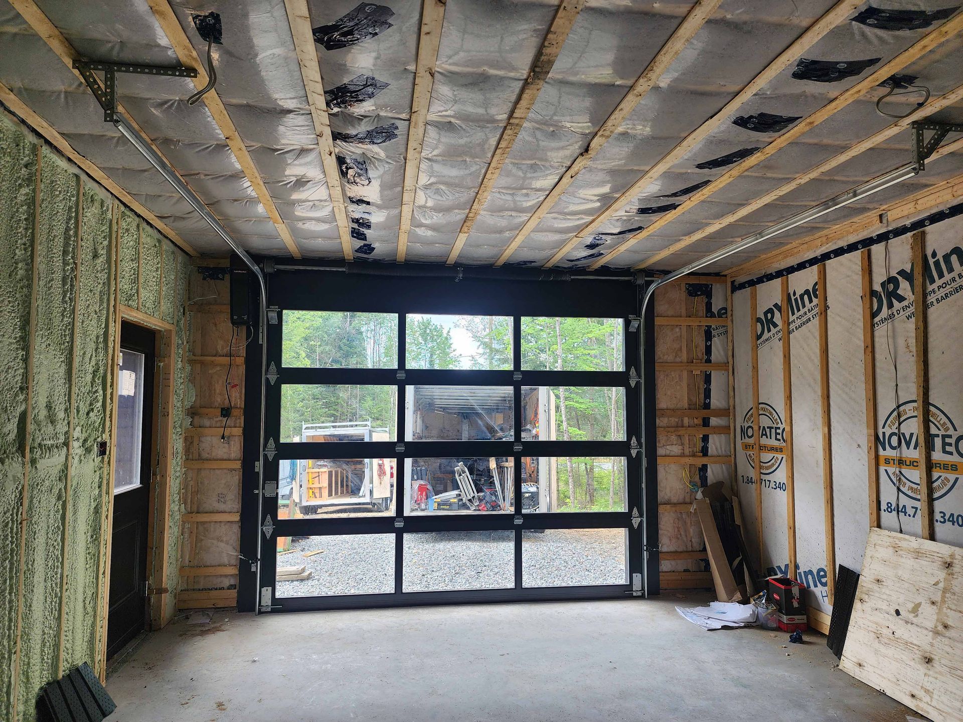 Un garage en construction avec une grande porte de garage vitrée.
