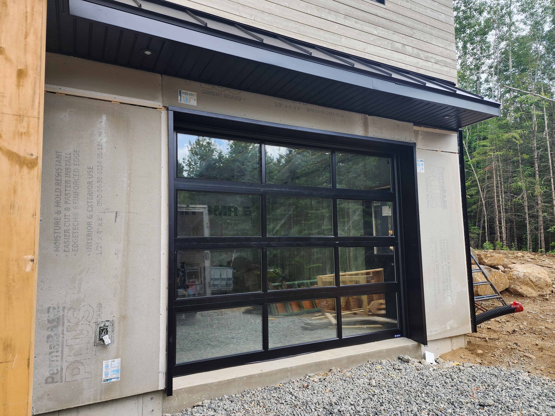 Une porte de garage avec beaucoup de fenêtres se trouve sur le côté d'une maison.