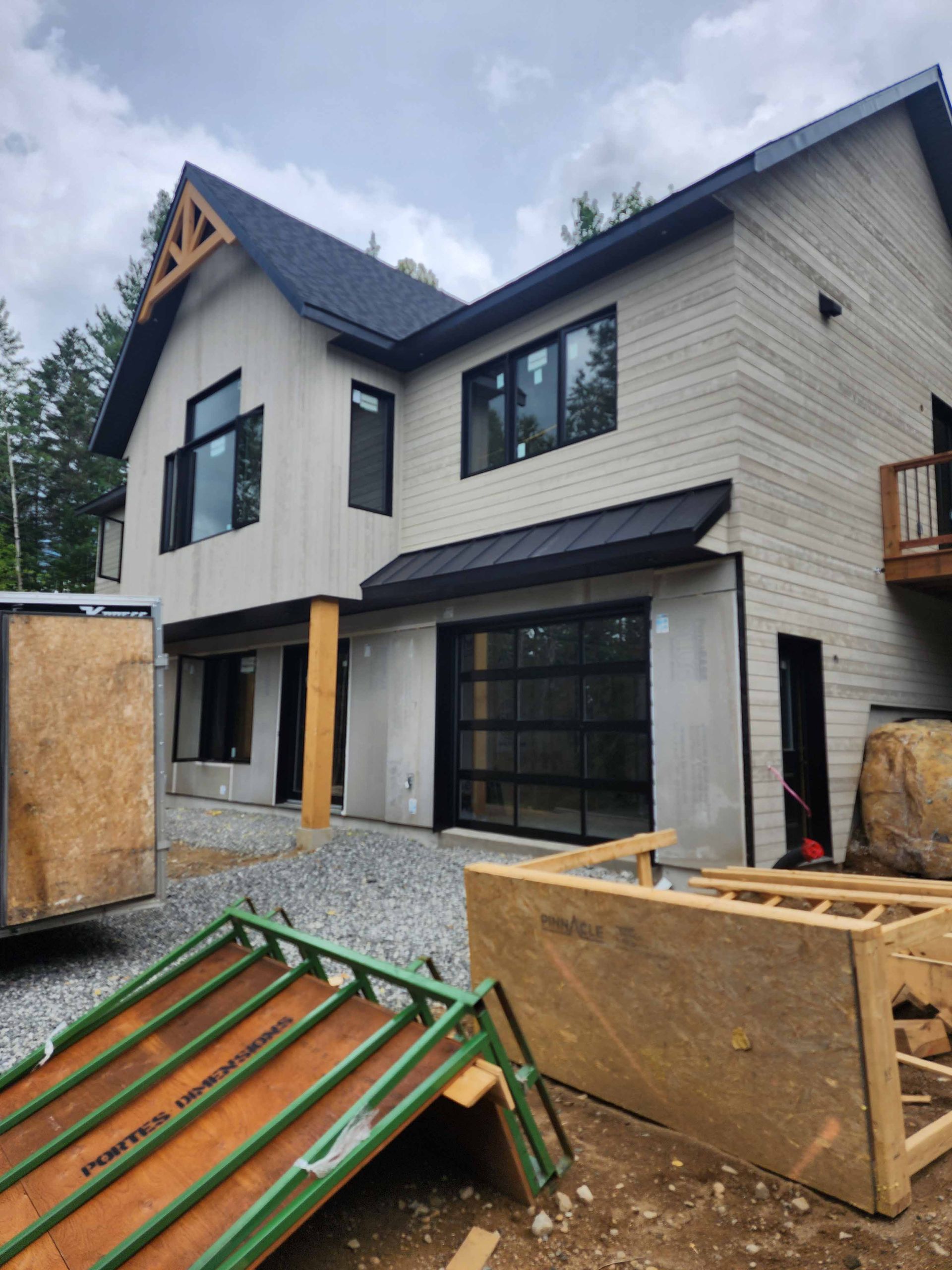 Une maison en construction avec une caravane devant