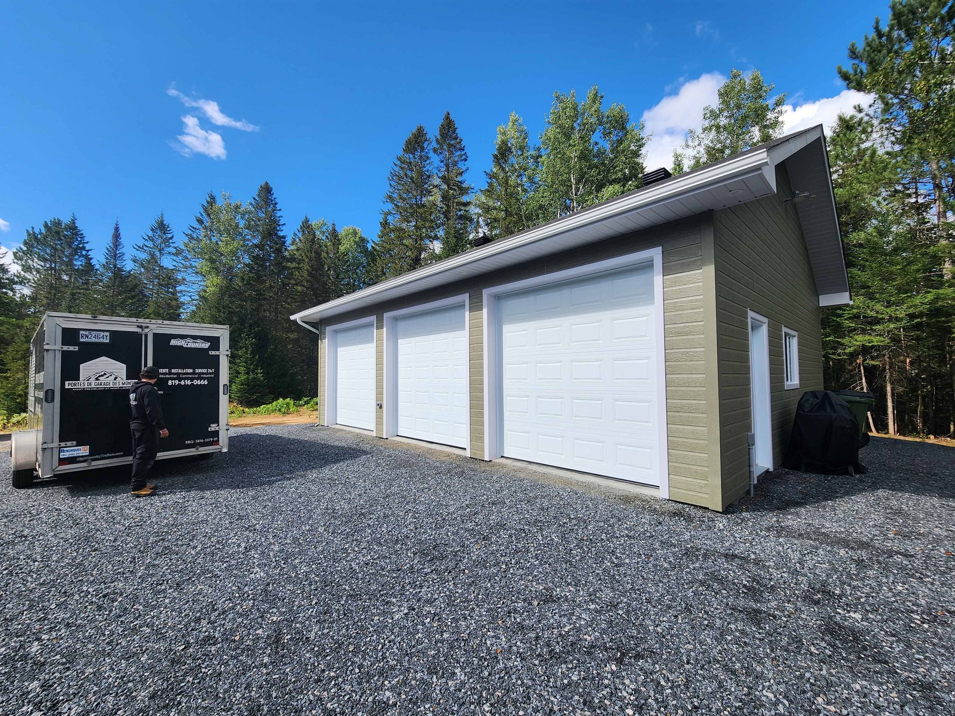Un garage avec une remorque garée devant