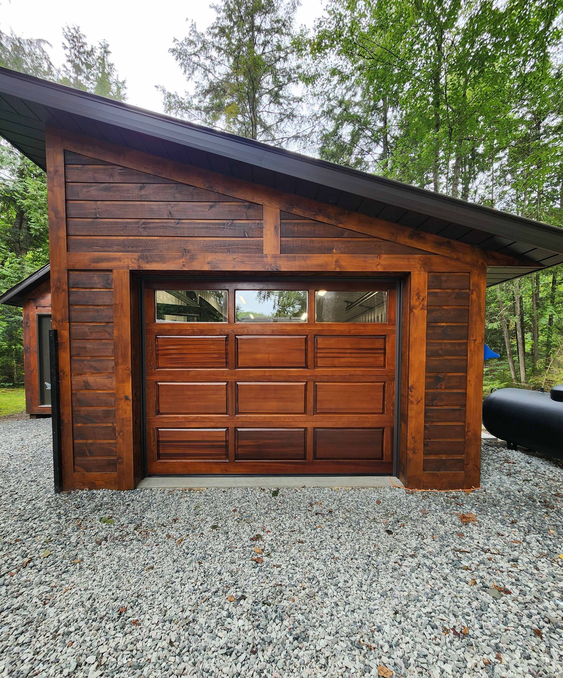 Un garage en bois avec une grande porte de garage en bois