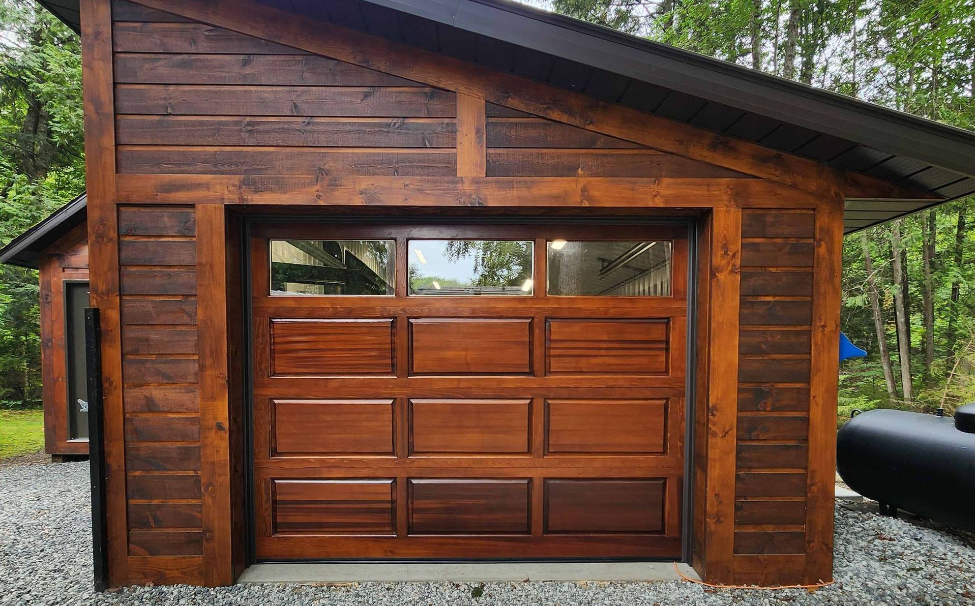 Un garage en bois avec une grande porte de garage en bois.
