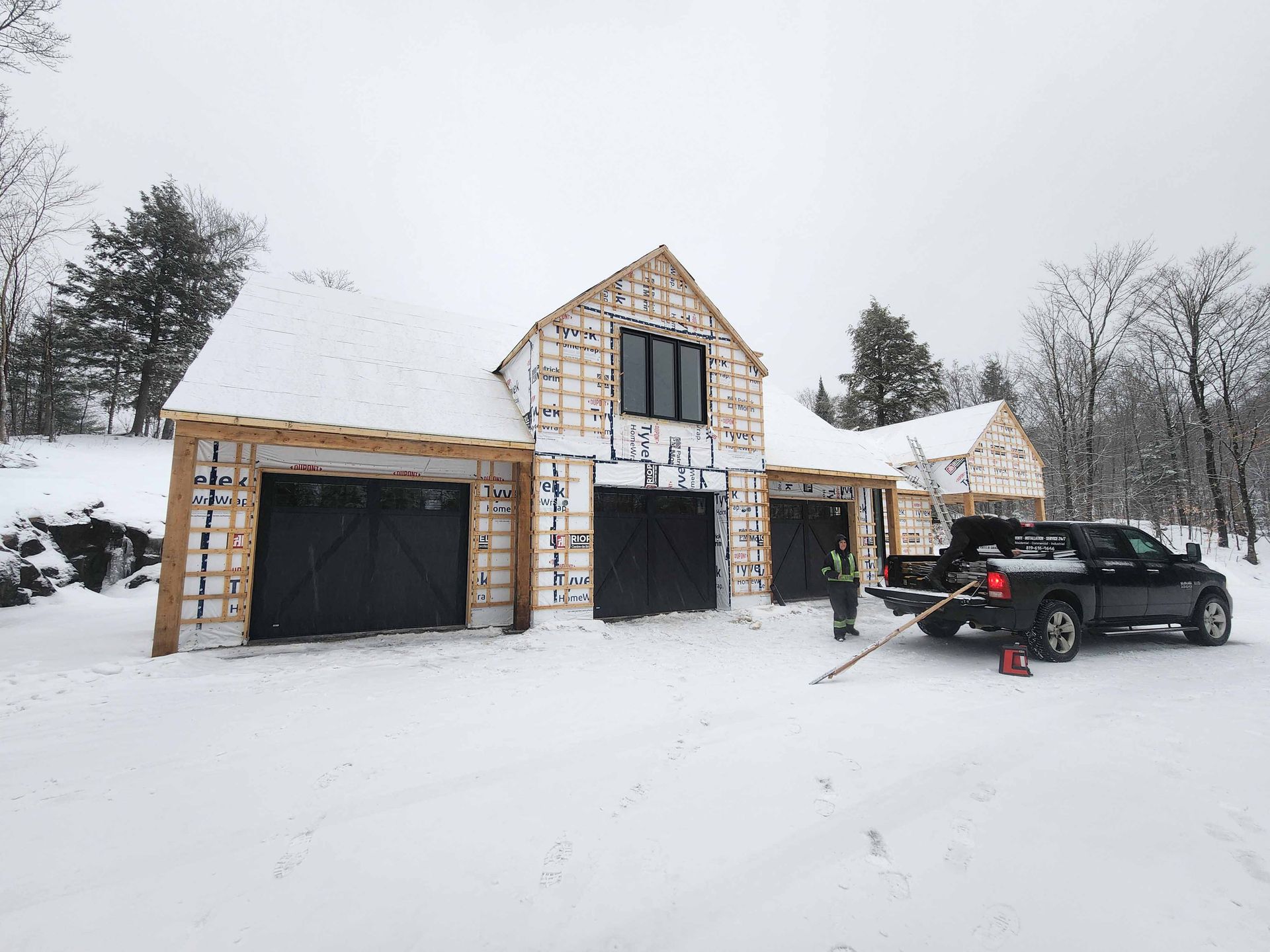 Un camion est garé devant une maison en construction sous la neige.
