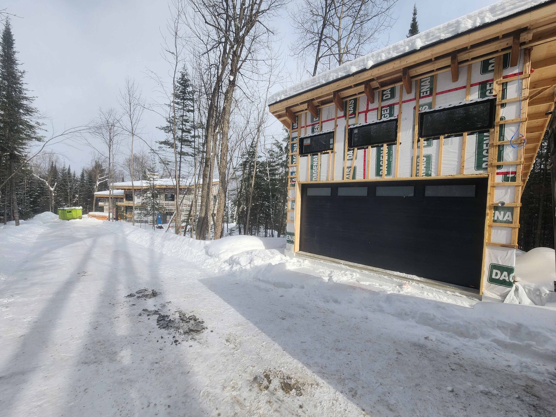 Une porte de garage est en cours de construction dans la neige.