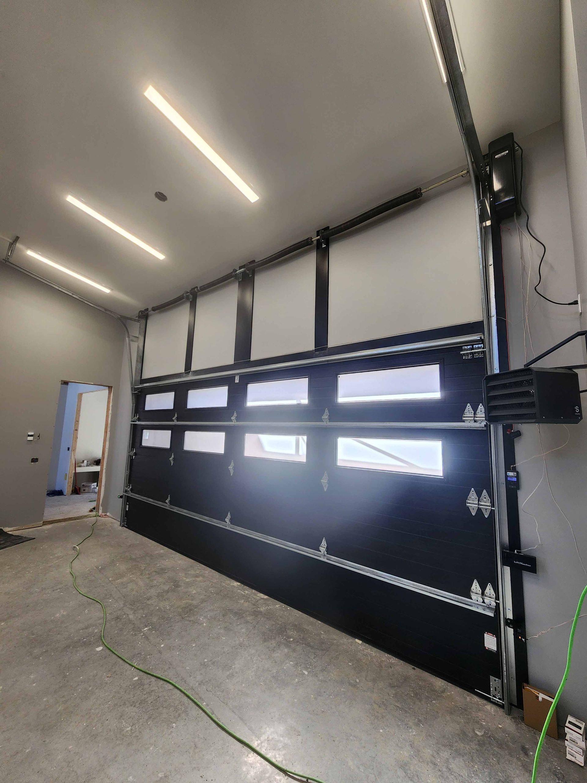 Une grande porte de garage noire avec beaucoup de fenêtres