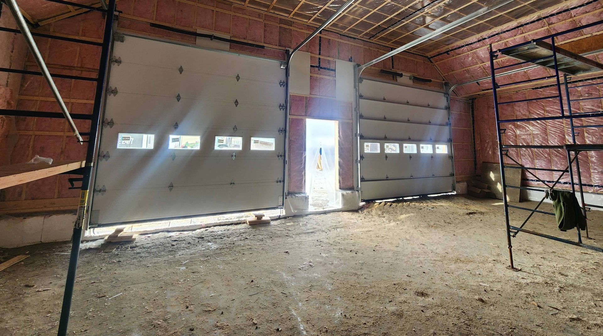 Un garage vide avec une grande porte de garage et un échafaudage.