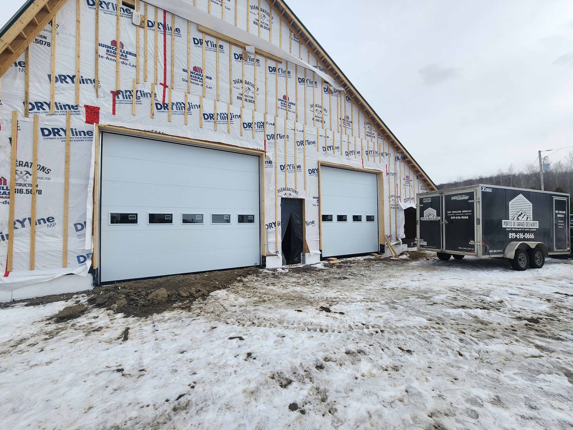 Un bâtiment en construction avec une remorque garée devant.