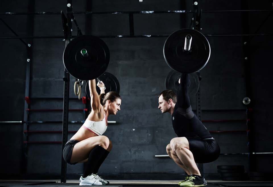 Woman and Man Lifting a Barbell - Working Out in Mount Laurel in NJ
