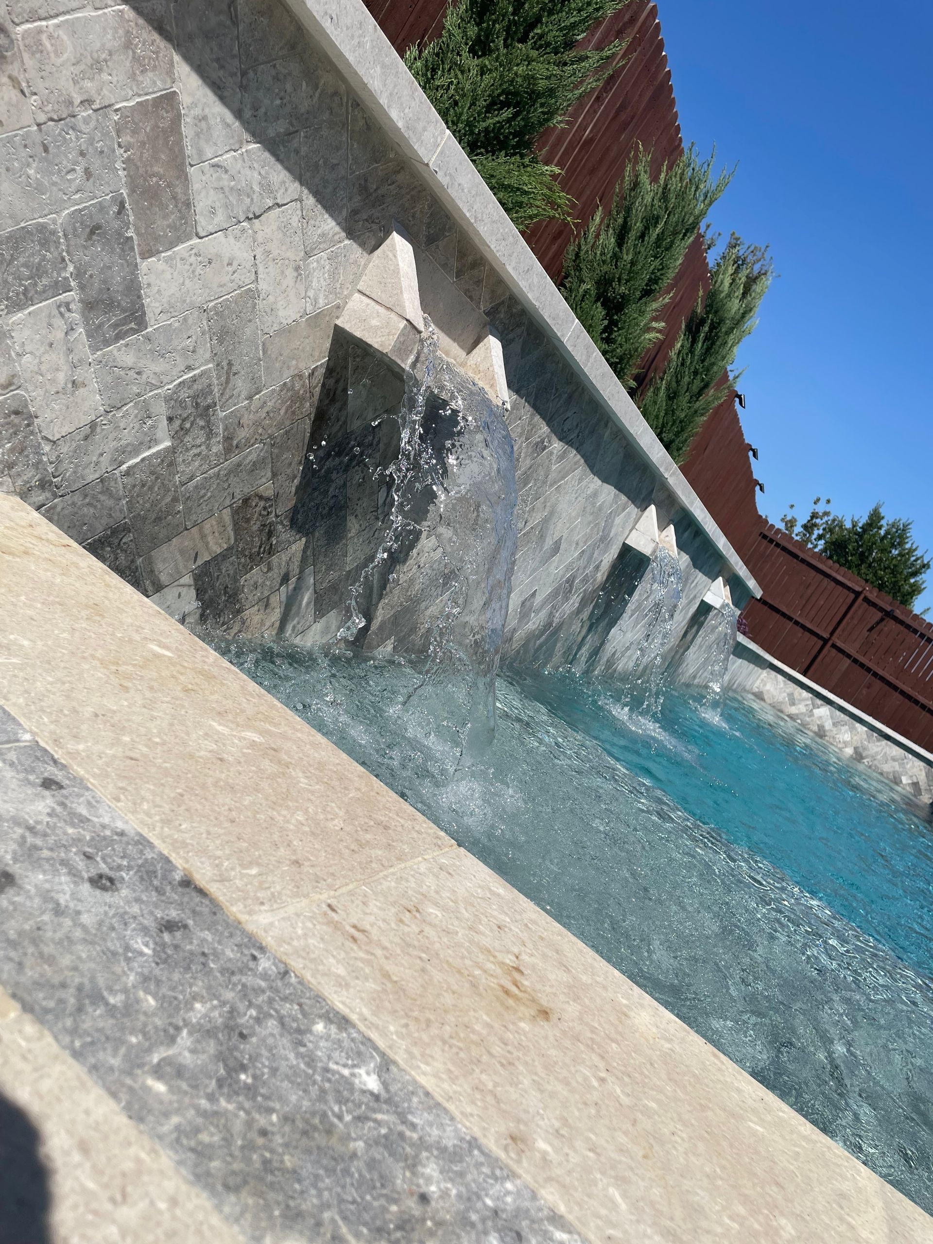 A swimming pool with a waterfall in the middle of it.