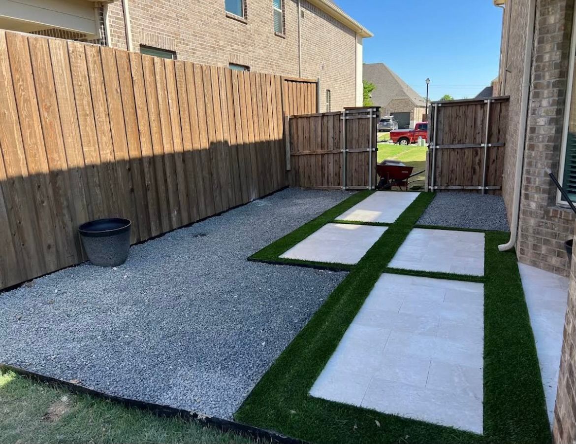 A backyard with a wooden fence and artificial grass