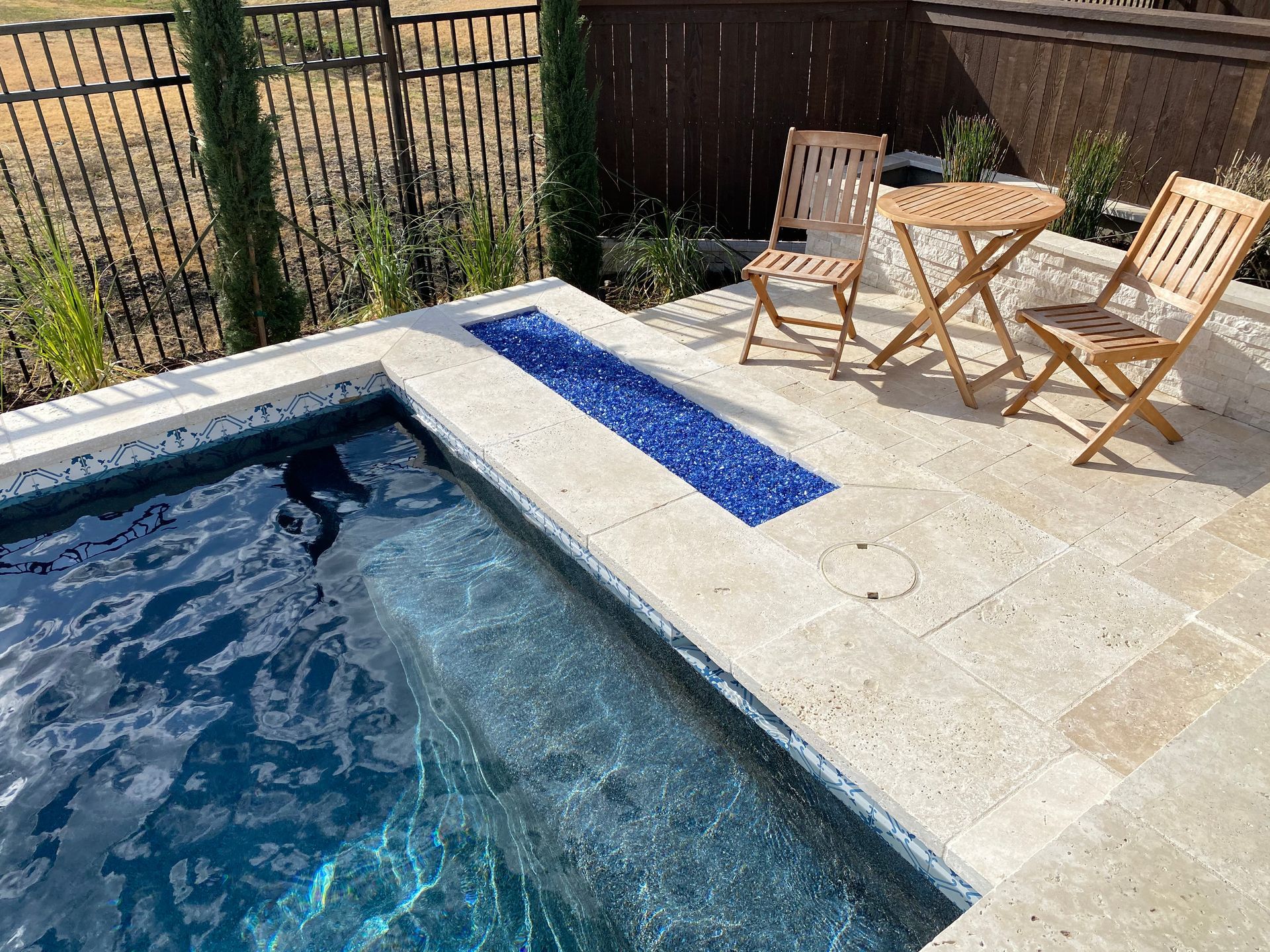 A swimming pool with a table and chairs next to it.