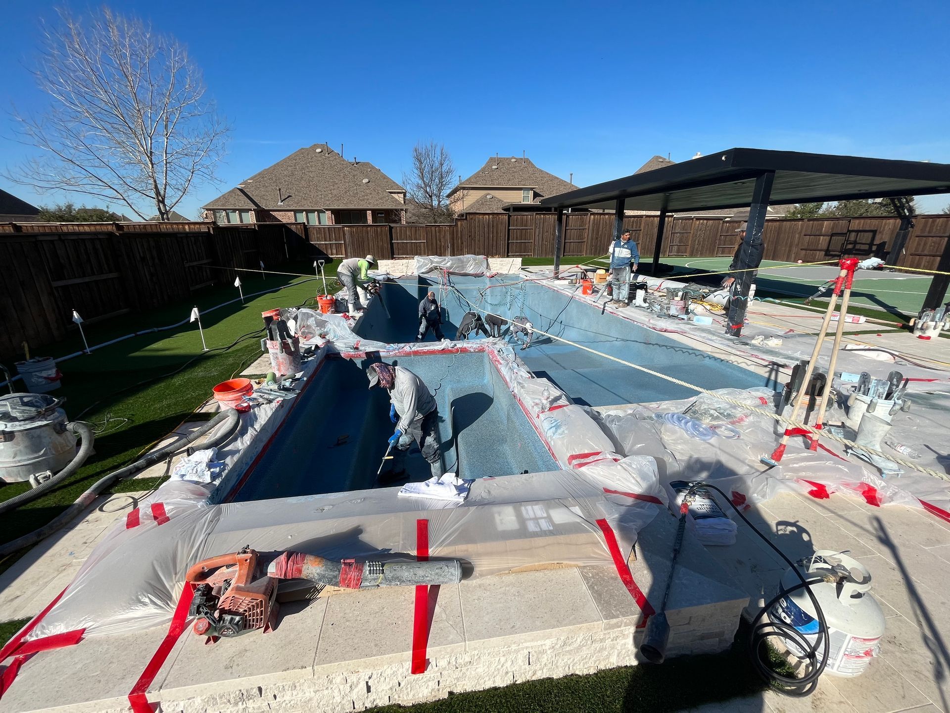 A large swimming pool is being built in a backyard.