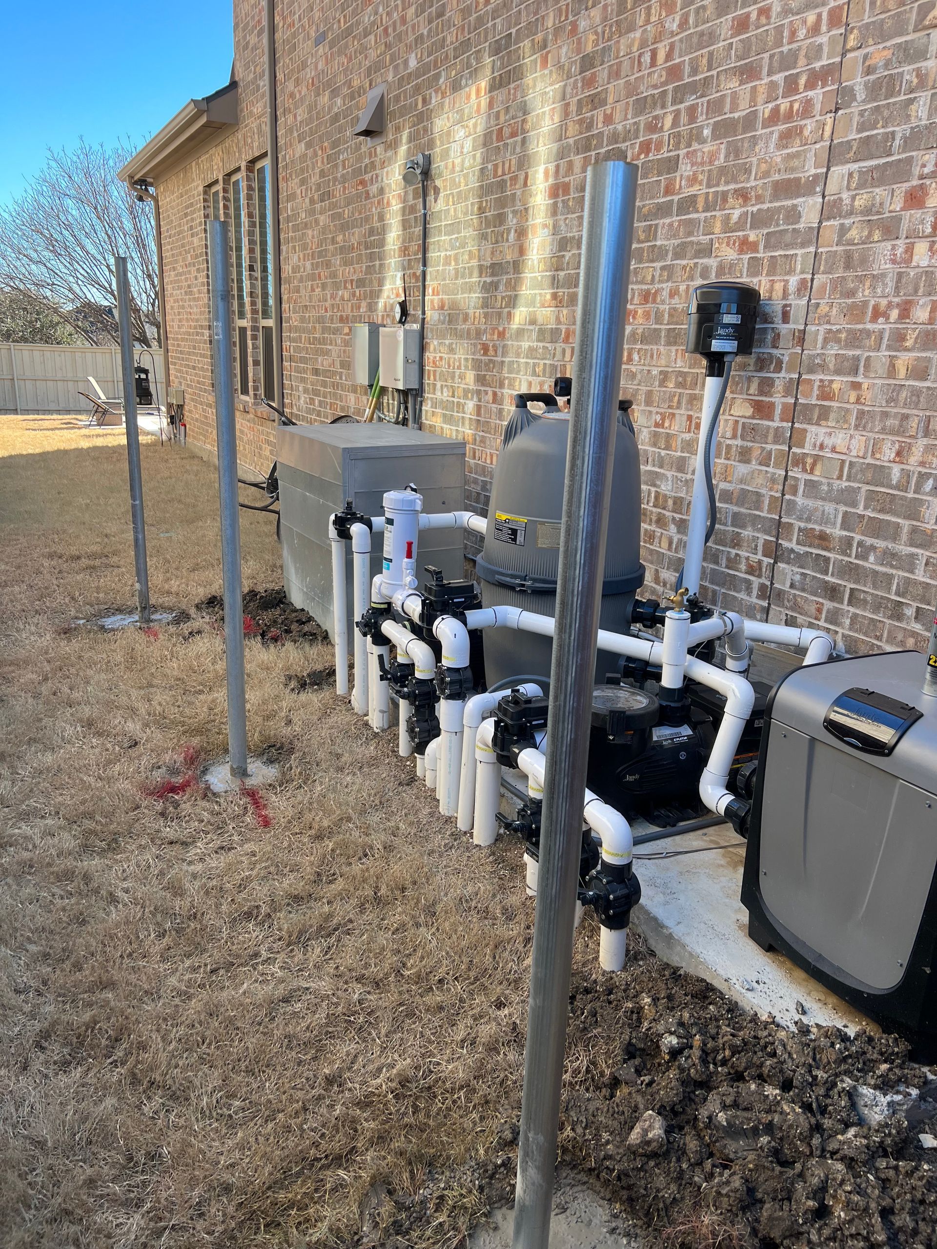 A row of pipes are lined up in front of a brick building.