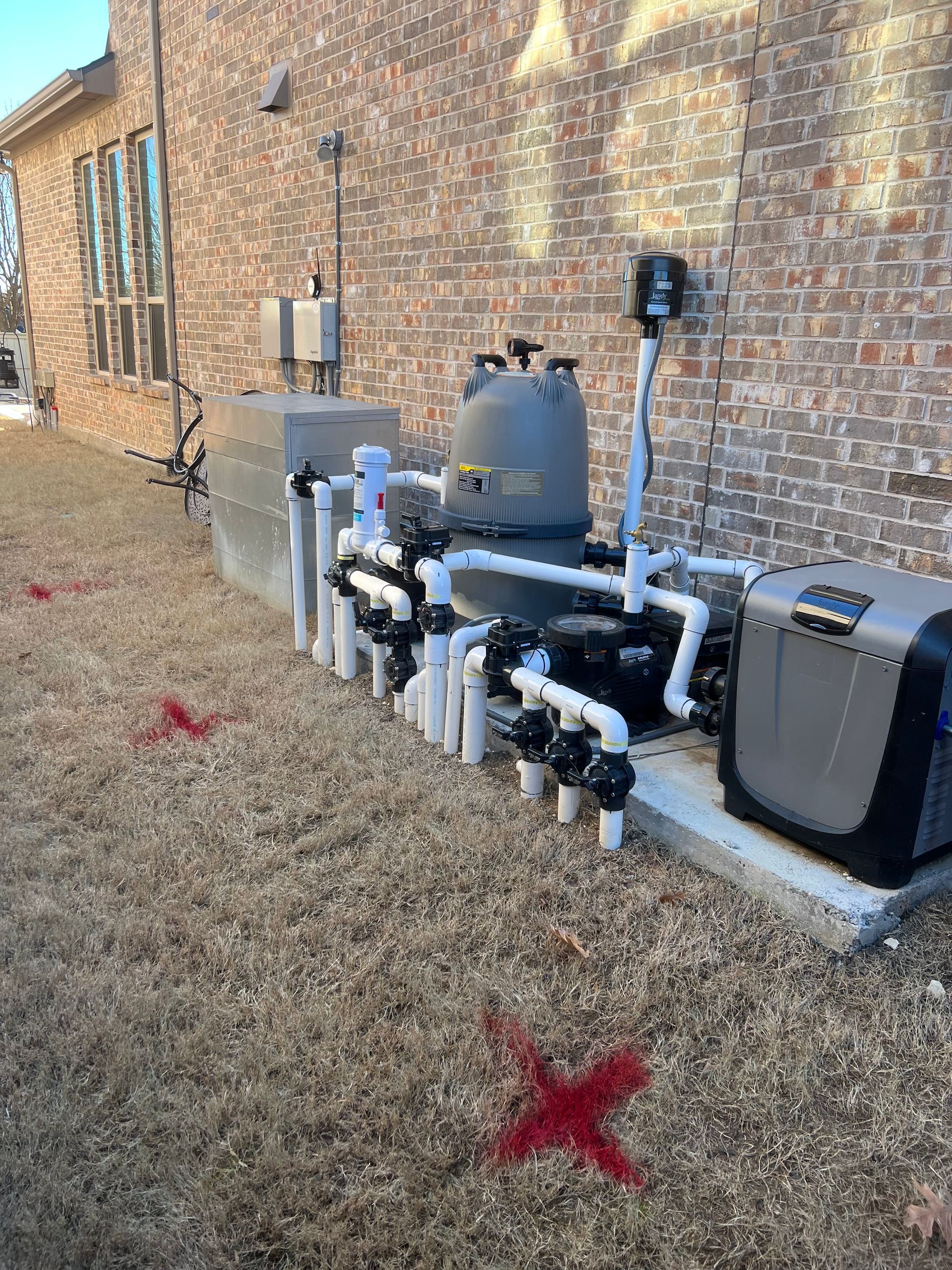 A swimming pool system is being installed in the backyard of a house.