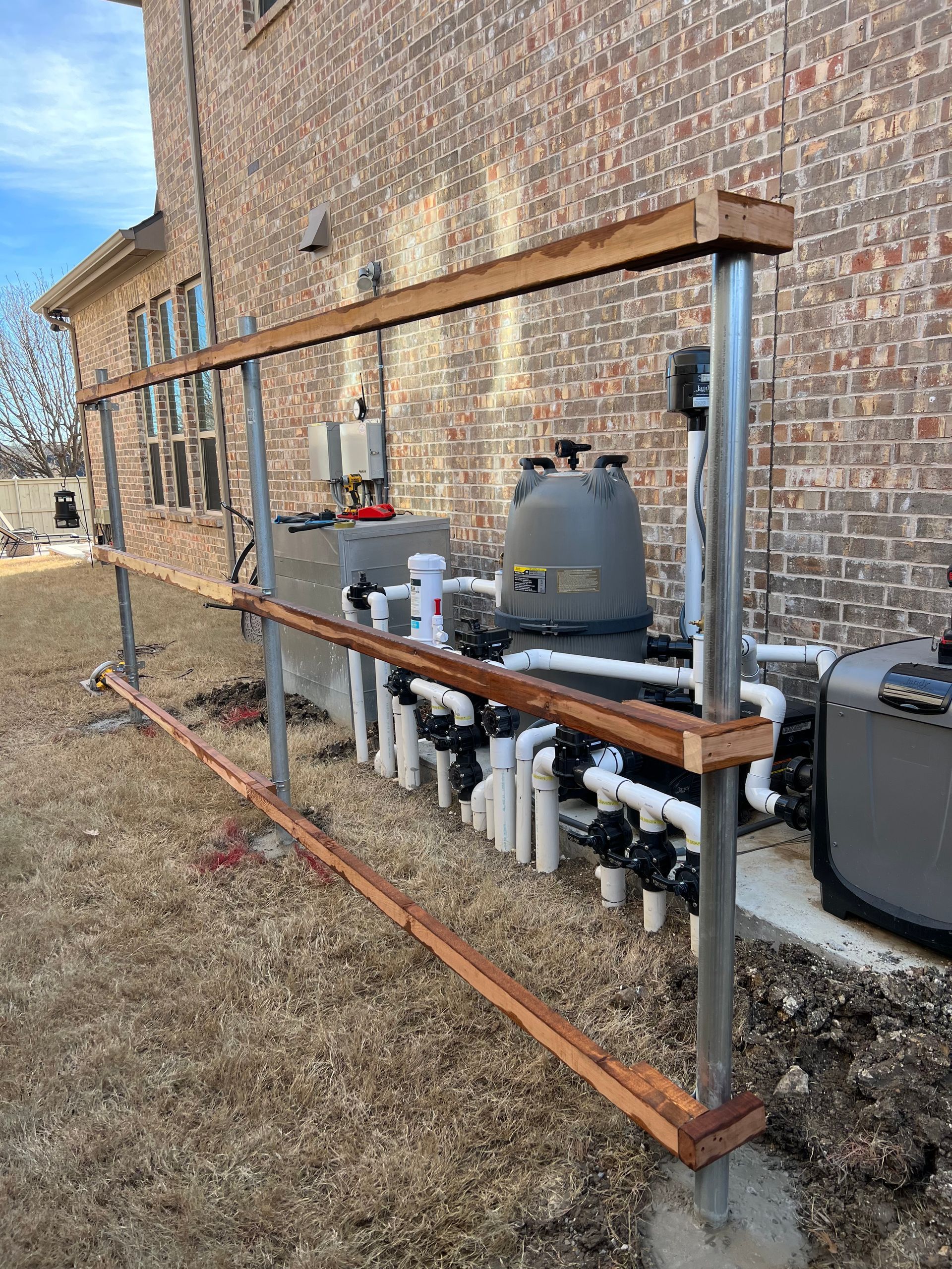A wooden fence is being built around a swimming pool.