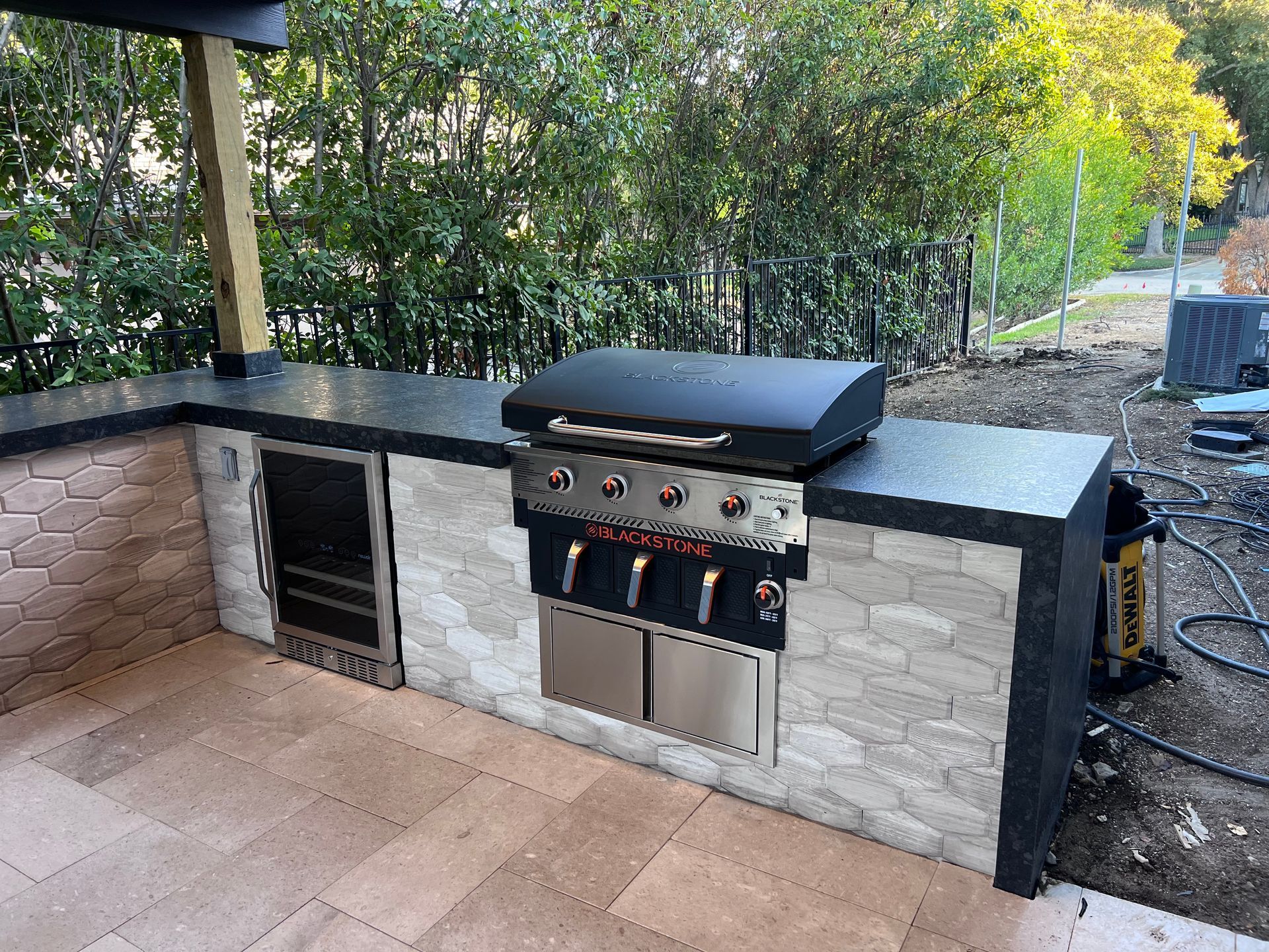 A grill is sitting on top of a counter in an outdoor kitchen.