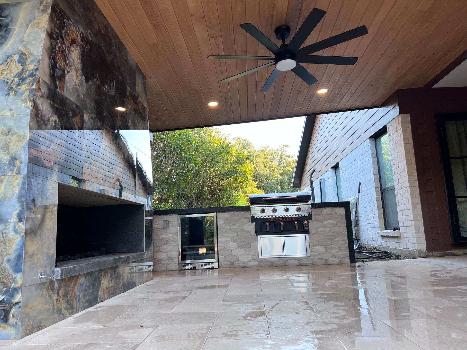 A ceiling fan is hanging from the ceiling of a patio area.