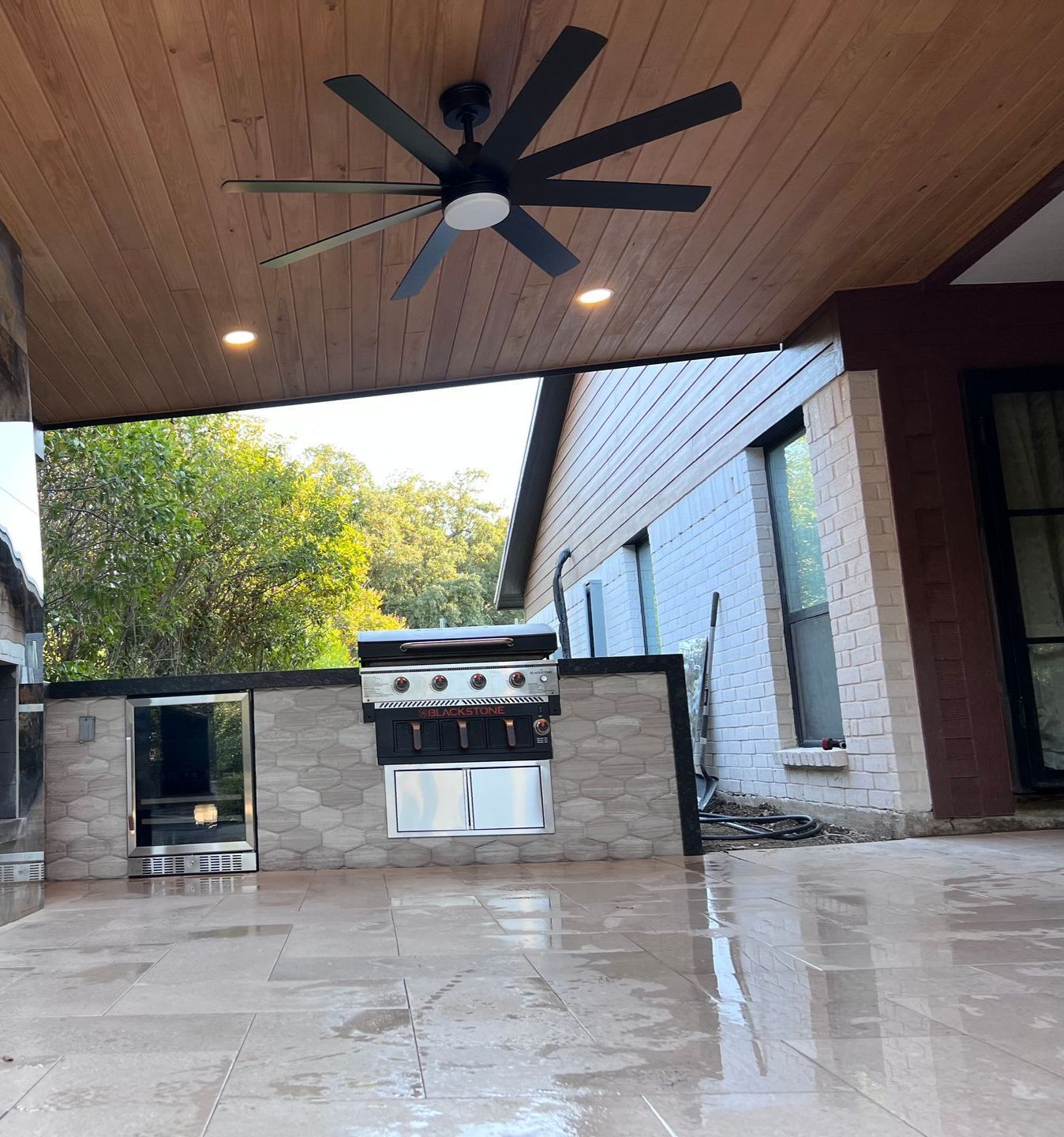 A ceiling fan is hanging from the ceiling above a grill